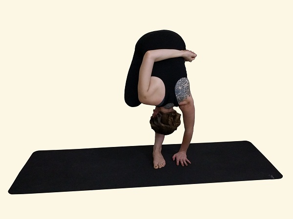 Beautiful Yogi Girl Standing In Yoga Asana, Vriksasana, Tree Pose On Grey  Background, Low Key Shot. Standing On One Foot, In Half Lotus Position,  Hands Above The Head Clasped Together In Anjali